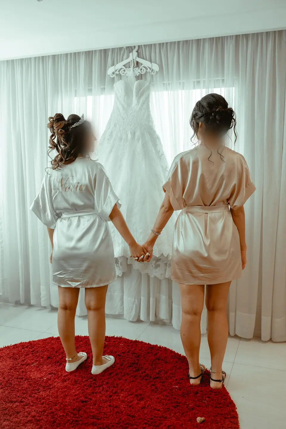 Prova günü askıdaki gelinliğe bakan iki kişi, arkadan
